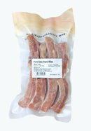 Packaged pork baby back ribs with a label on a white background