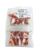 Packaged pork soft bone cut with visible marbling on a white background