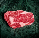 Marbled raw steak on a dark textured surface