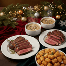 Steak and tater tots with mushroom soup on a festive table setting.